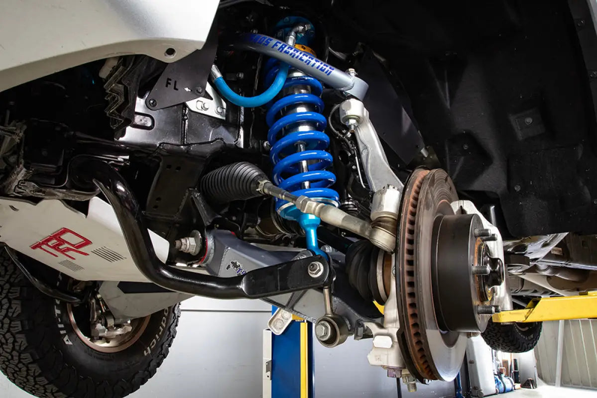 Installed Total Chaos Tundra Lower Control Arm with suspension components, including coilovers, on a Toyota Tundra.
