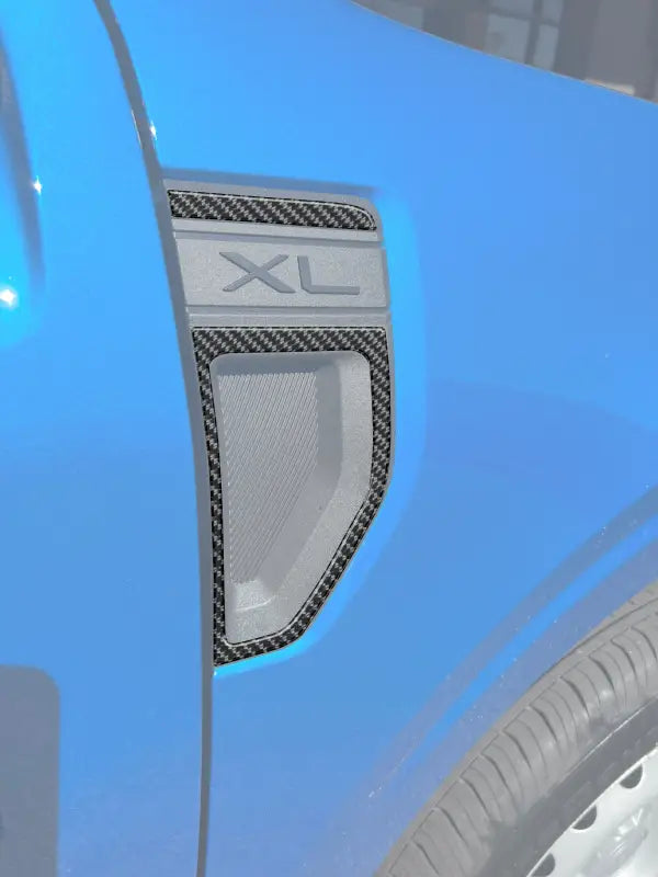 Blue vehicle fender with XL trim showcasing Ford Maverick fender emblem overlays
