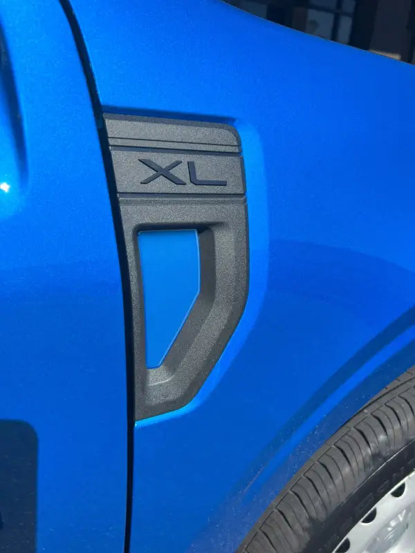 Blue car with XL trim showcasing fender emblem pocket and emblem pocket inserts