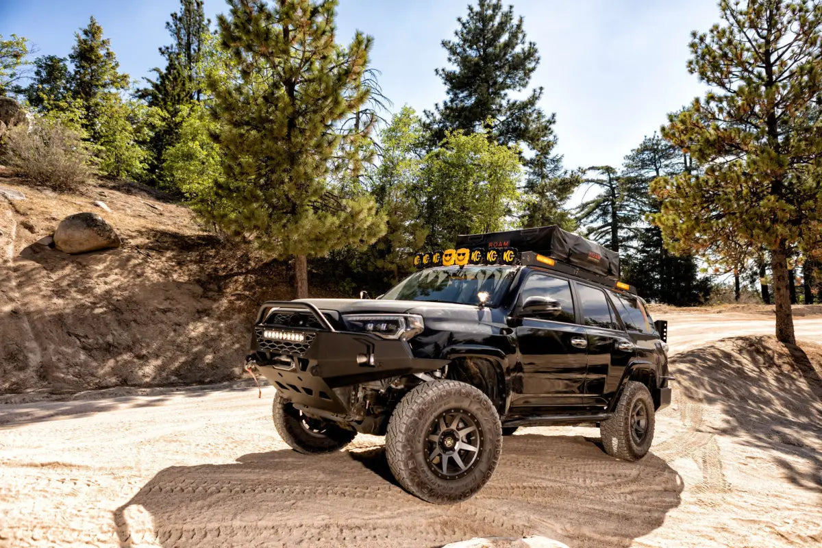 Off-road SUV equipped with FLEX ERA® 3 LED light pods and additional lighting gear, parked in a rugged outdoor setting.