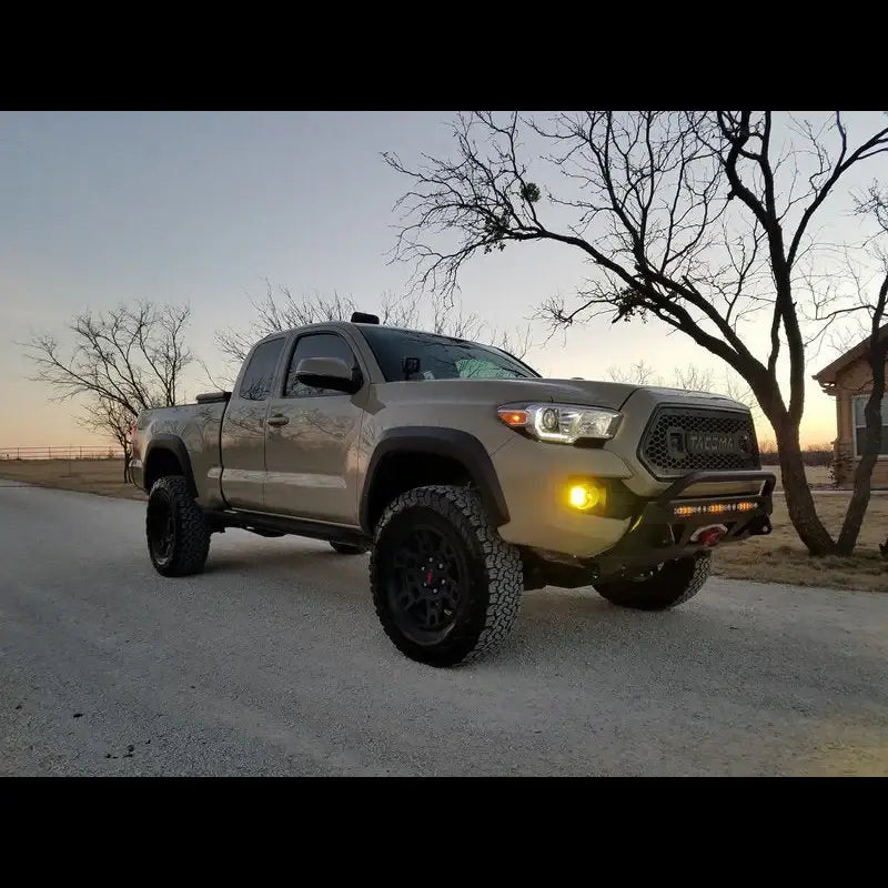 Side view of a Toyota Tacoma with a Lo-Pro winch bumper, highlighting off-road tires and durable bumper design for 2016+ models.