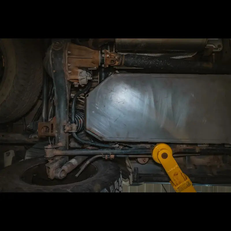 Detailed underside view of GX460 skid plate, highlighting its CNC plasma cut design and protective coverage for fuel tank.