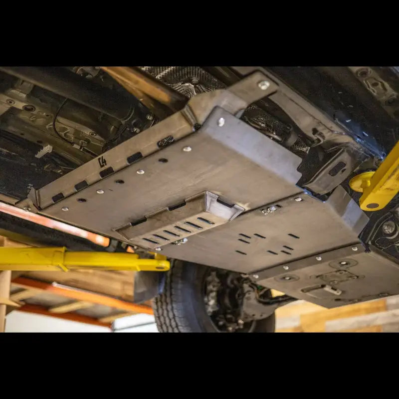 Close-up view of Tacoma skid plates installed, highlighting durable steel construction and bolt-on design for 2005+ models.