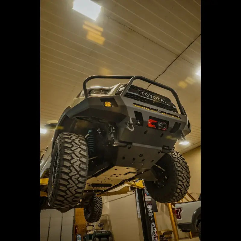 Front view of a lifted Tacoma with skid plates installed, emphasizing off-road readiness and engine protection for 2005+ models.