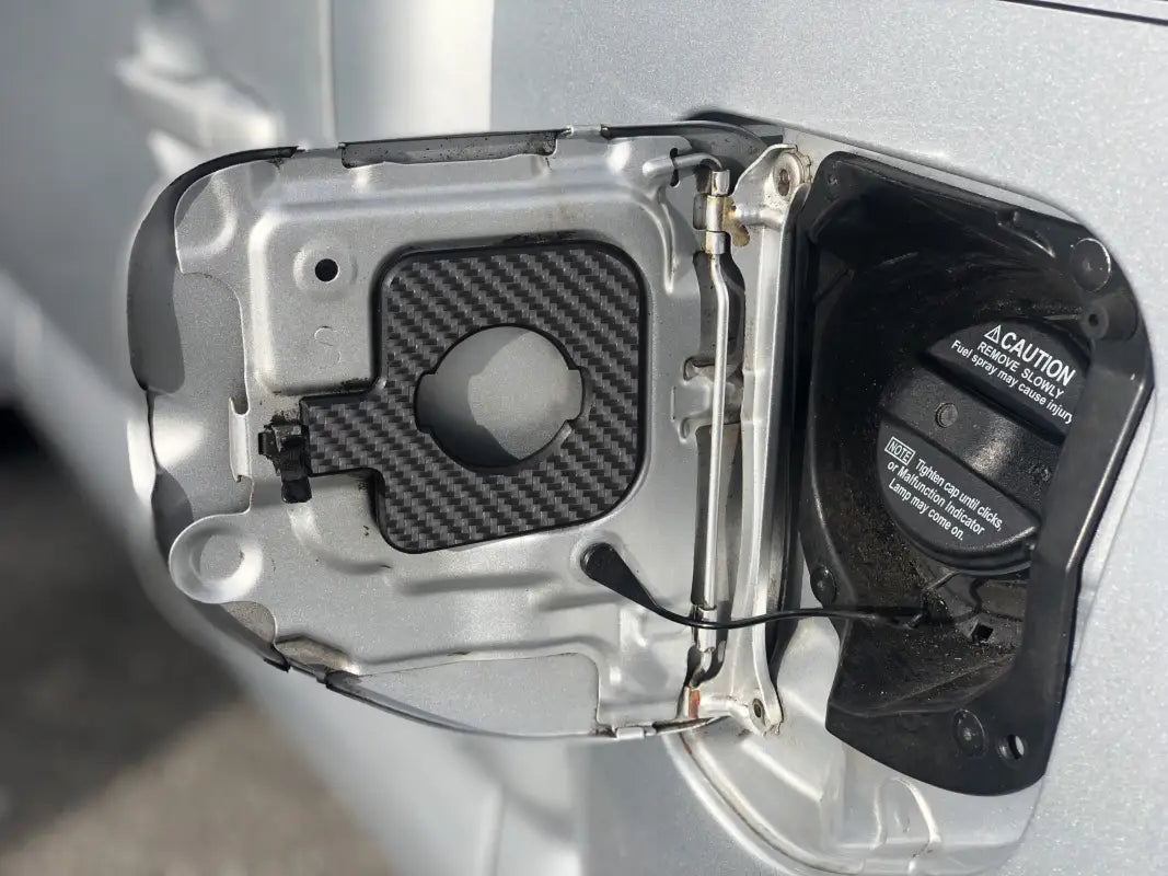 Gas cap holder insert with tri-color stripes for Toyota Tacoma 2005-2023, securely mounted inside the fuel door.