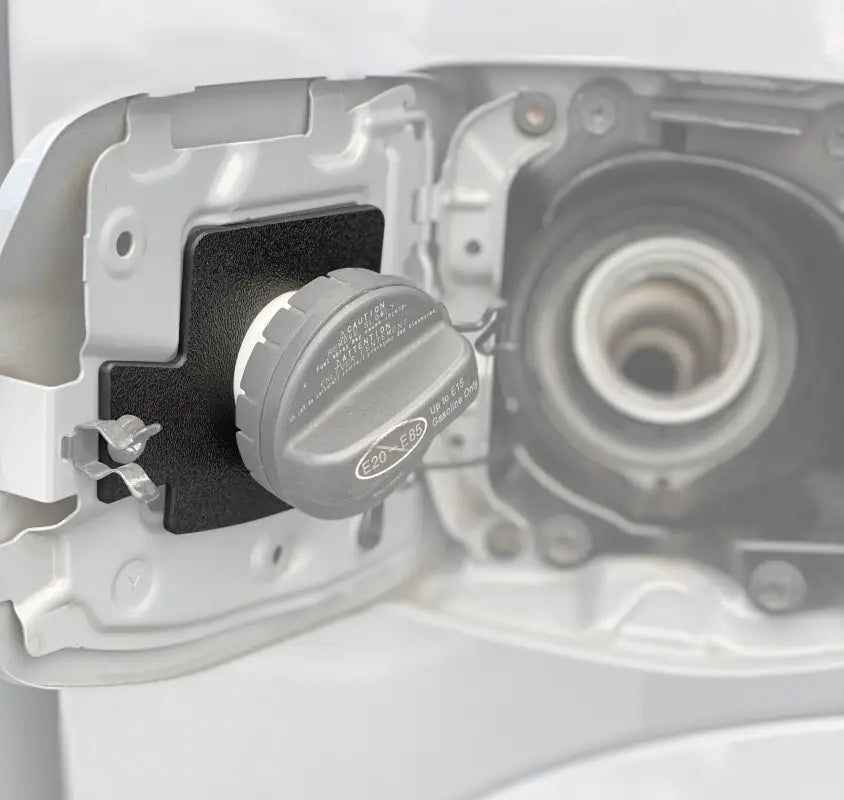 Gas cap holder insert for 2005-2023 Toyota Tacoma, black textured design, securely mounted inside the fuel door.