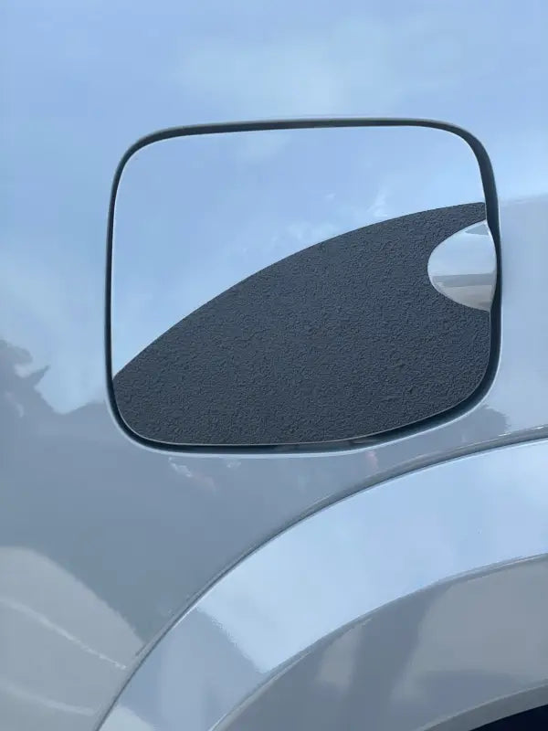 Close-up of gas lid protection overlay with plain black textured design, fits 2016-2023 Toyota Tacoma.