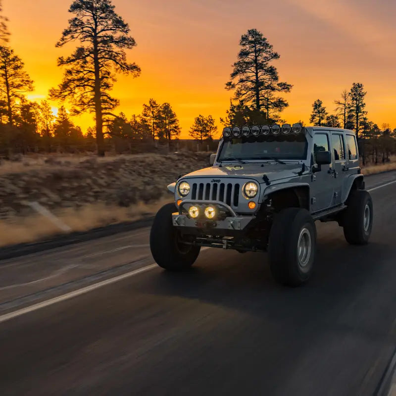 Jeep with Gravity® Titan™ 6" LED lights driving at sunset, showcasing powerful illumination for off-road exploration.