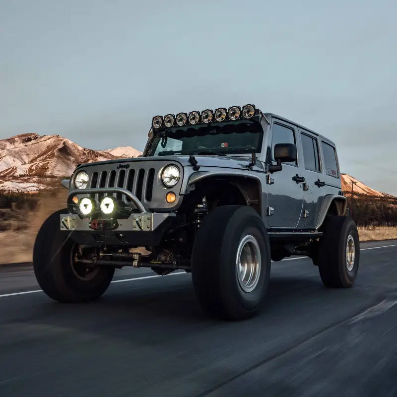 Close-up of Jeep with Gravity® Titan™ 6" LED lights and roof-mounted light bar, designed for off-road and trail adventures.