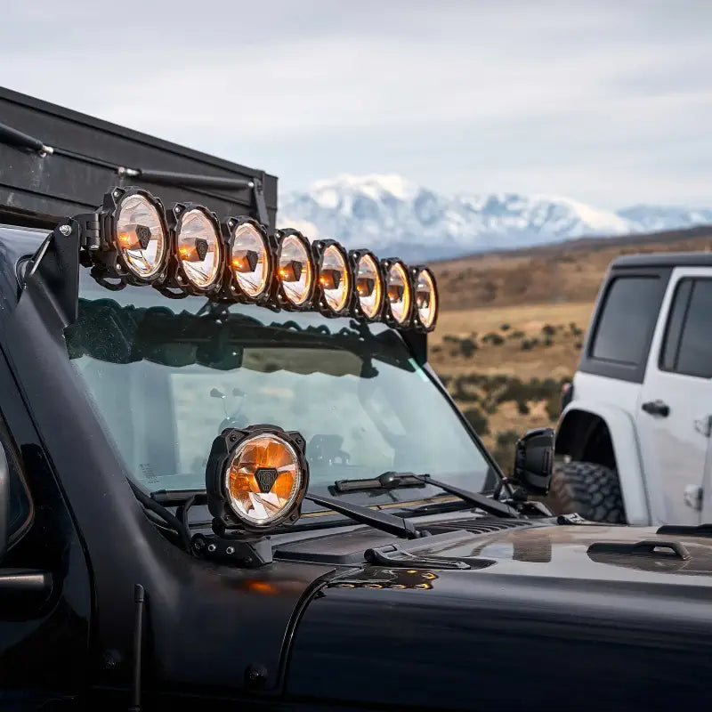 Close-up of Gravity Titan 6" LED Spot Beam lights in amber mode, mounted on a vehicle for off-road use.