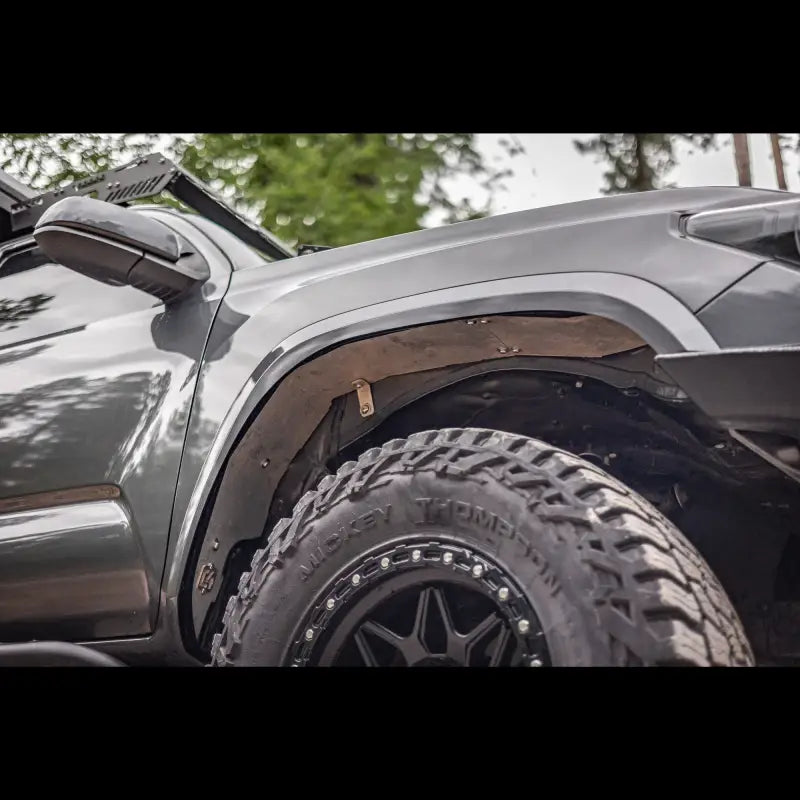 Side profile of a 3rd Gen Tacoma with high clearance aluminum fender liner, emphasizing off-road readiness and sleek design.