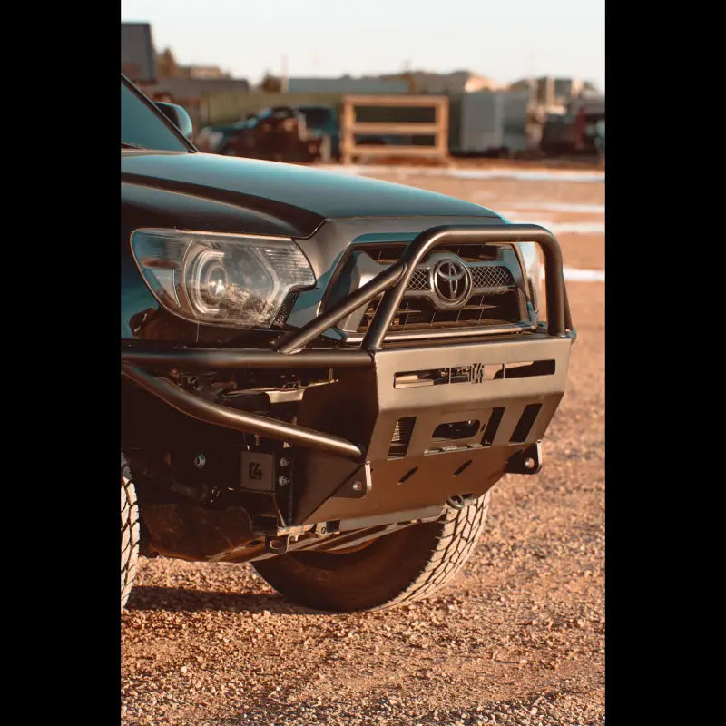 Front view of Toyota Tacoma with hybrid front bumper featuring a full bull bar, designed for 2012-2015 models.