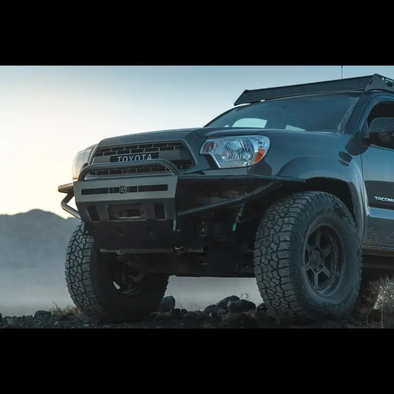 Close-up of Tacoma hybrid front bumper, winch-compatible, bolt-on fit for 2012-2015 models, on an off-road vehicle.