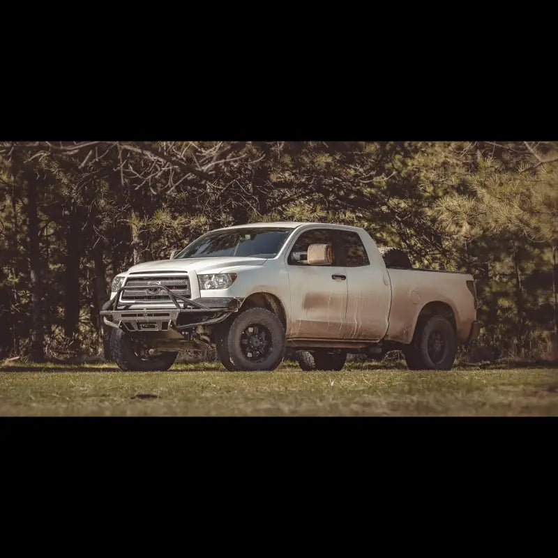 Full view of a 2007-2013 Tundra equipped with a Hybrid Front Bumper, parked in an outdoor setting with rugged terrain.