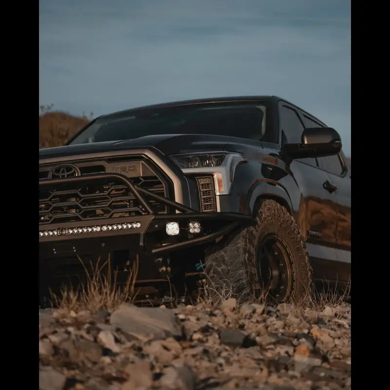 Low-angle view of Tundra Hybrid Bumper on a 3rd Gen Toyota Tundra 2022+, highlighting robust build, LED light mounts, and bare steel finish.