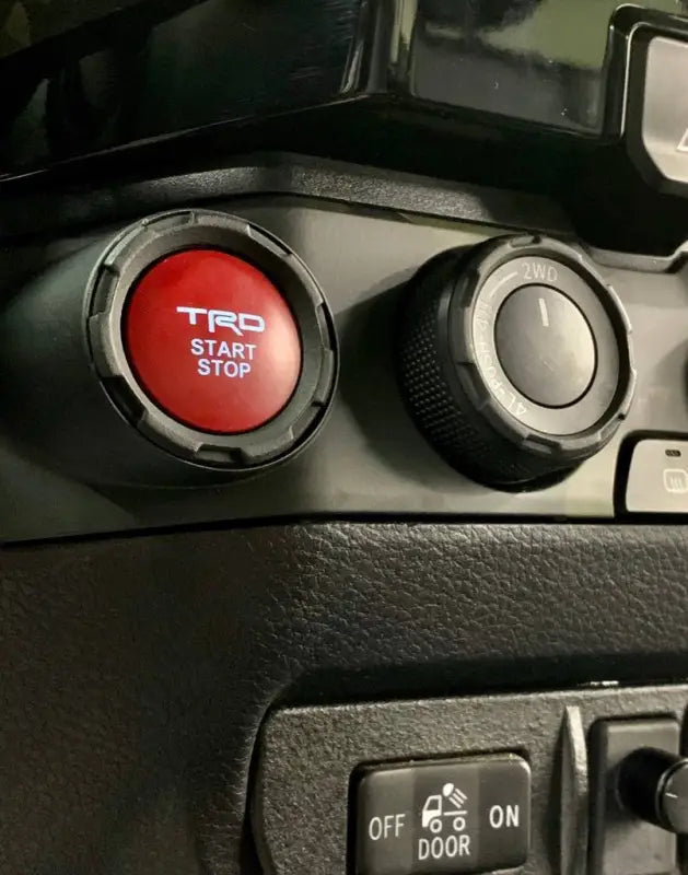 Installed red chrome delete trim around the start-stop button in a Toyota Tacoma, enhancing the interior style.