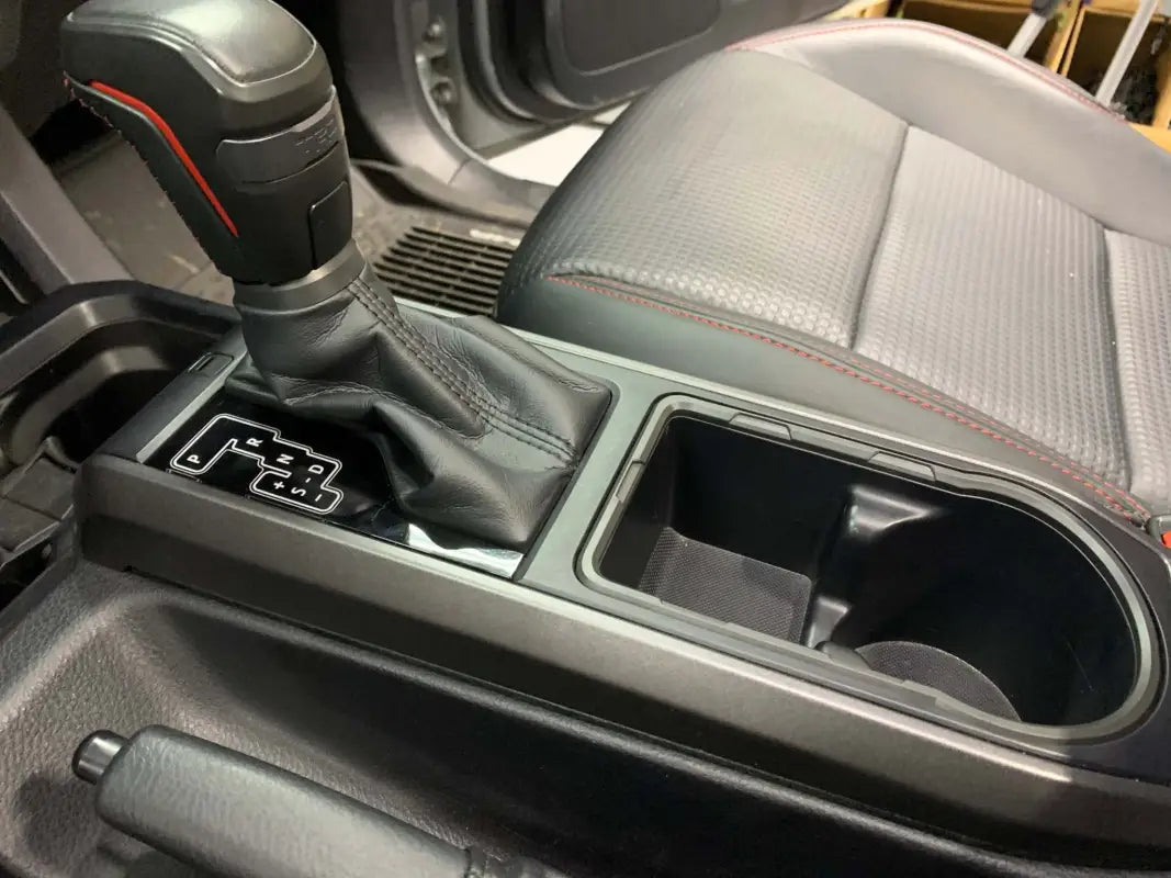 Toyota Tacoma center console with installed black chrome delete kit, providing a sleek and cohesive interior look.