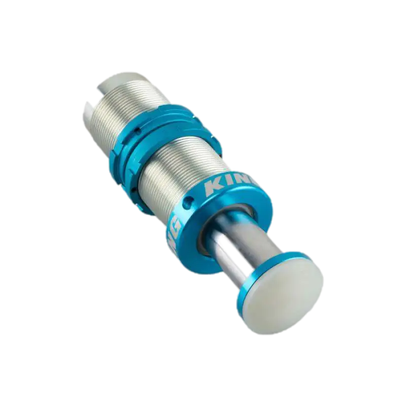 Compact King 2.0 Bump Stop-BS2120 featuring a unique piston design and anodized blue finish, ideal for rock crawling and rugged terrains.