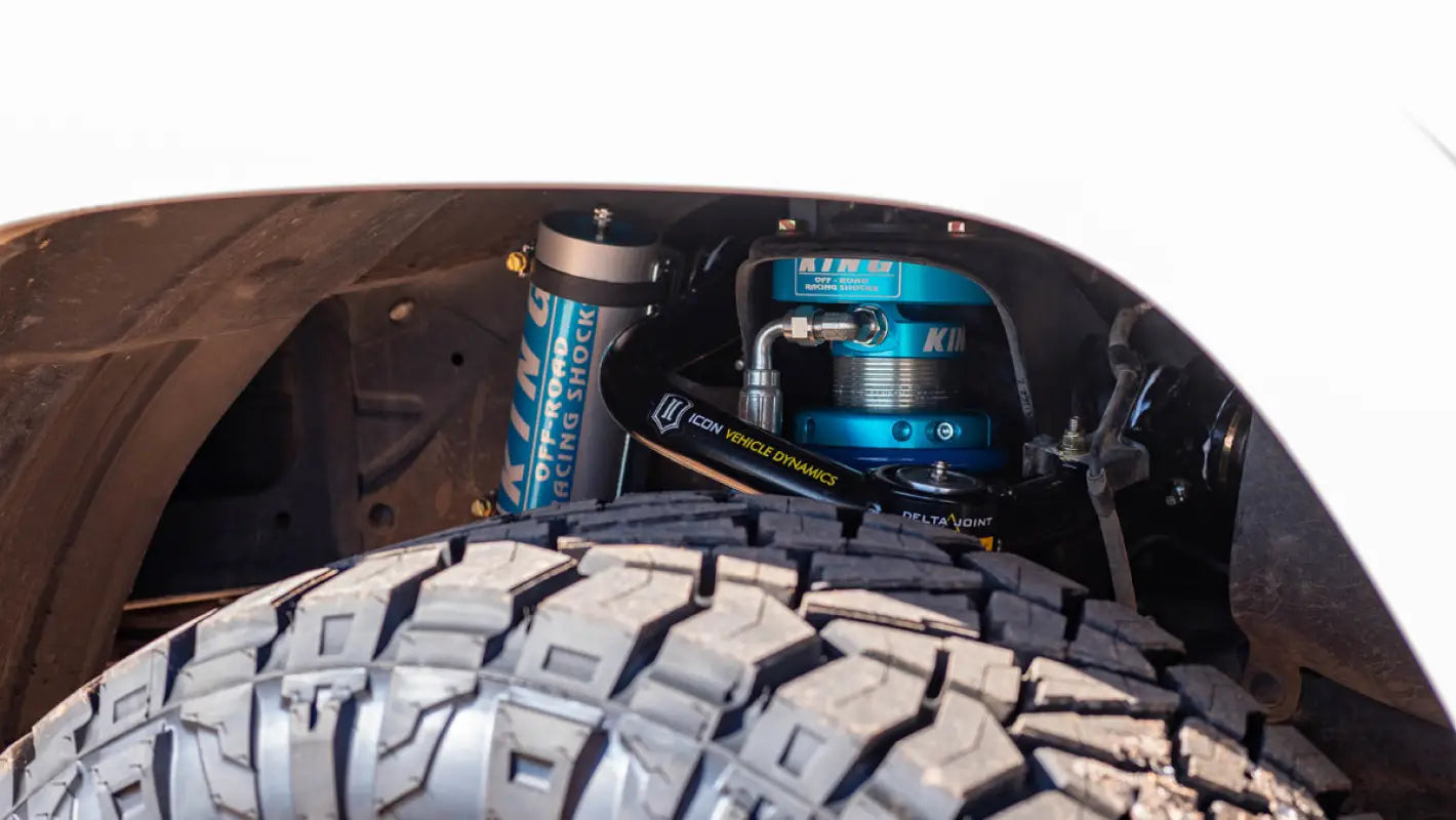 Close-up of King 2.5 RR EXT Travel Coilovers installed on a Toyota 4Runner, highlighting the blue anodized shocks and off-road capability.