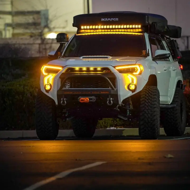 Toyota 4Runner with LED DRL Fang Light Bezel Kit in amber, parked in an urban setting, showcasing enhanced lighting and stylish upgrades.