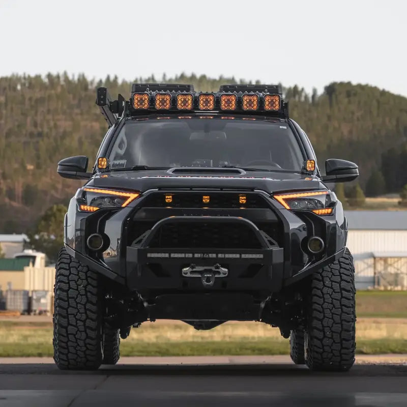 Front view of a black 5th Gen 4Runner with Lo Pro Winch Bumper, LED light bars, and off-road tires, showcasing rugged design.