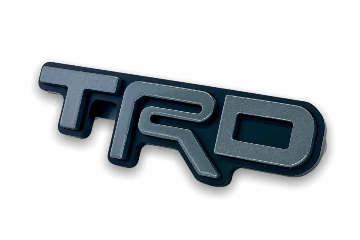 Gray and black TRD emblem logo grille badge for route protection vehicle upgrade