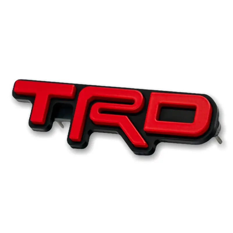 Red and black TRD emblem logo grille badge for route protection and vehicle styling