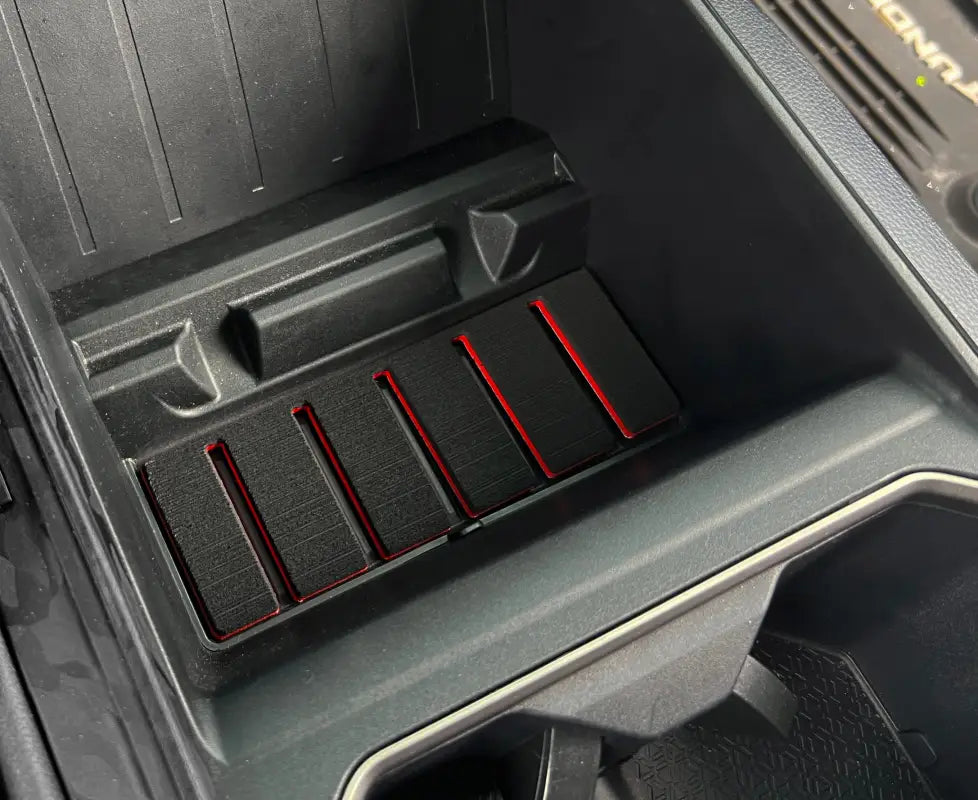 Close-up view of lower center console foam inserts with red accents fitted in a Toyota Tundra or Sequoia, designed for a sleek interior upgrade.