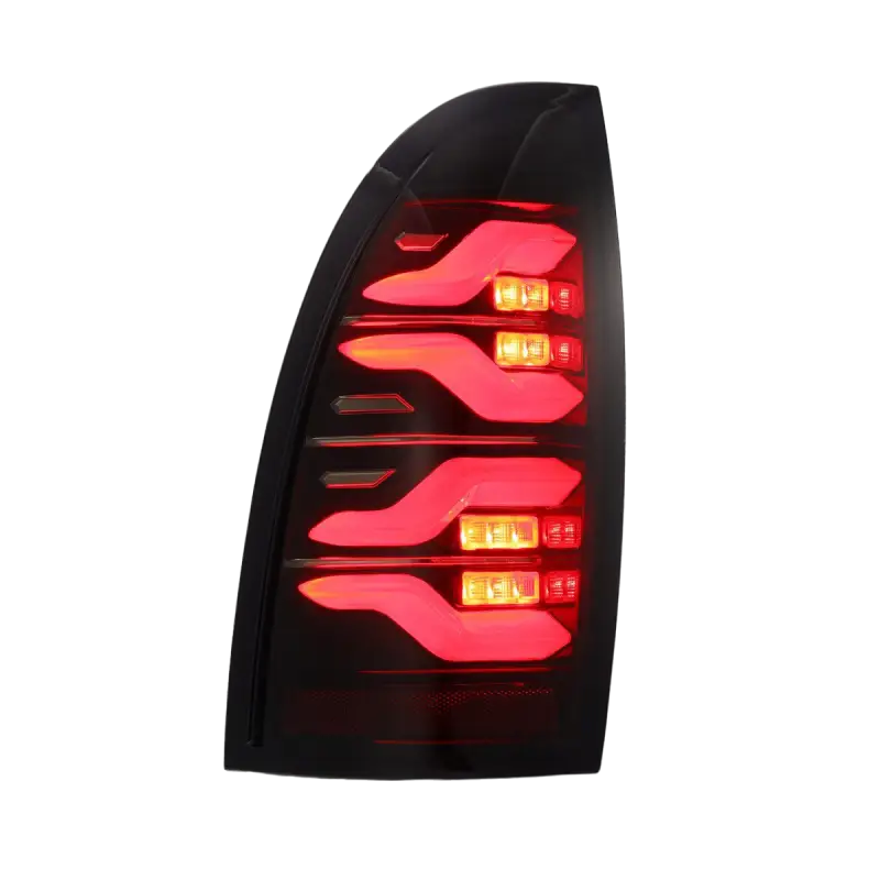 Illuminated LUXX-Series LED tail light for Toyota Tacoma, featuring vibrant red lighting and a sleek black housing.