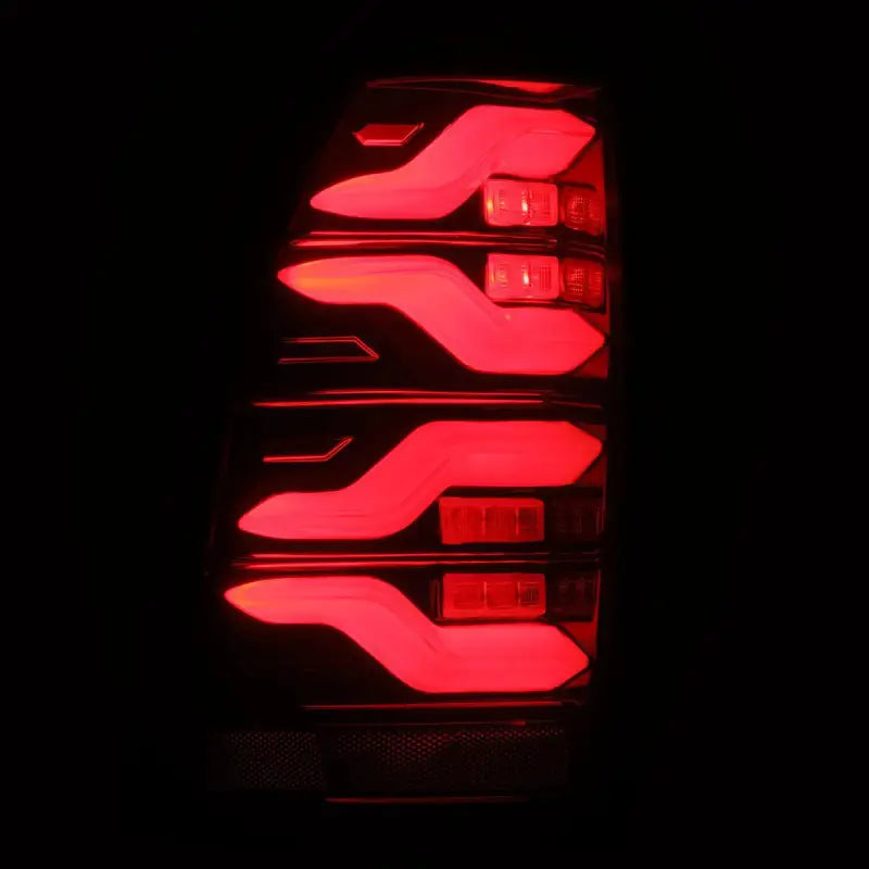 Close-up of illuminated LUXX-Series LED tail light for Toyota Tacoma, highlighting its bright red LED design.