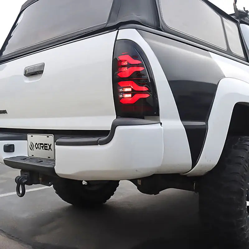 Rear view of Toyota Tacoma with LUXX-Series LED tail lights installed, emphasizing their sleek design and bright illumination.