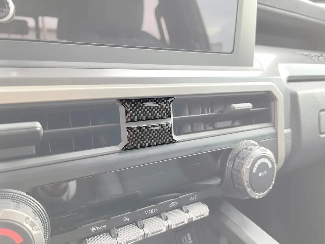 Carbon fiber middle A/C vent accent trim installed on a 2024 Toyota Tacoma interior, enhancing the dashboard design.