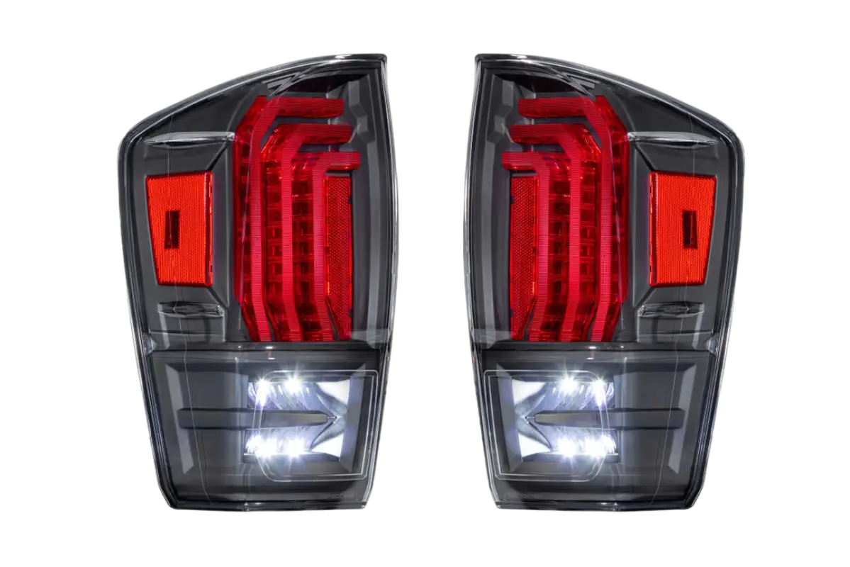 Rear view of Morimoto Tail Lights for Tacoma (2016-2023) with clear lens, showcasing illuminated LED brake and reverse lights.