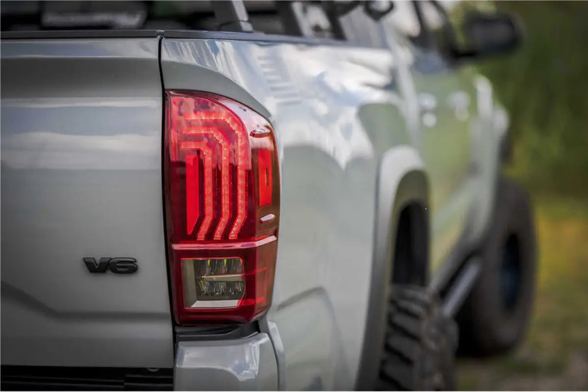 Installed Morimoto Tail Lights on a Tacoma (2016-2023) with red lens, highlighting precise OEM fitment and stylish LED design on a gray truck.