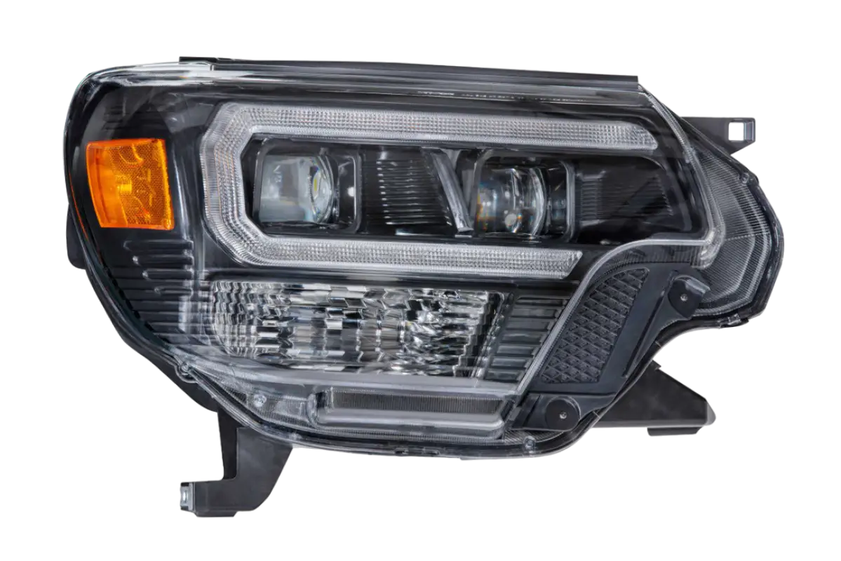 Close-up of Morimoto XB Hybrid LED headlight without amber DRL for Tacoma 2012-2015, highlighting clear lens and detailed craftsmanship.