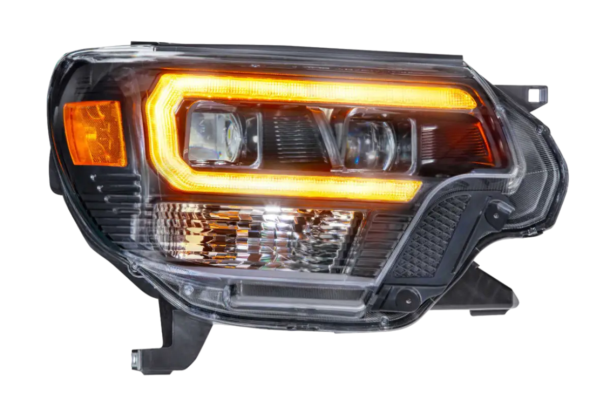 Close-up of Morimoto XB Hybrid LED headlight with amber DRL for Tacoma 2012-2015, showcasing sleek design and advanced lighting.