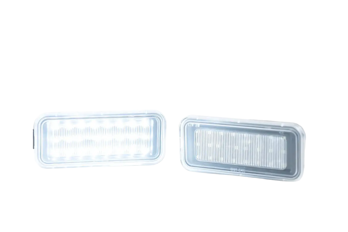 Illuminated Morimoto XB LED bed light replacements for Tacoma (2020-2023), emitting bright white light with a sleek, clear lens design.