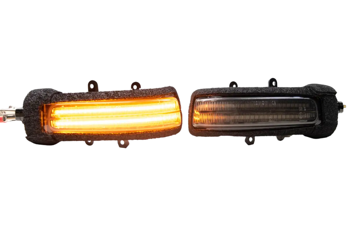 Morimoto XB turn signals for Tacoma (2012-2015) and 4Runner (2010-2013) with one illuminated in amber and the other unlit.