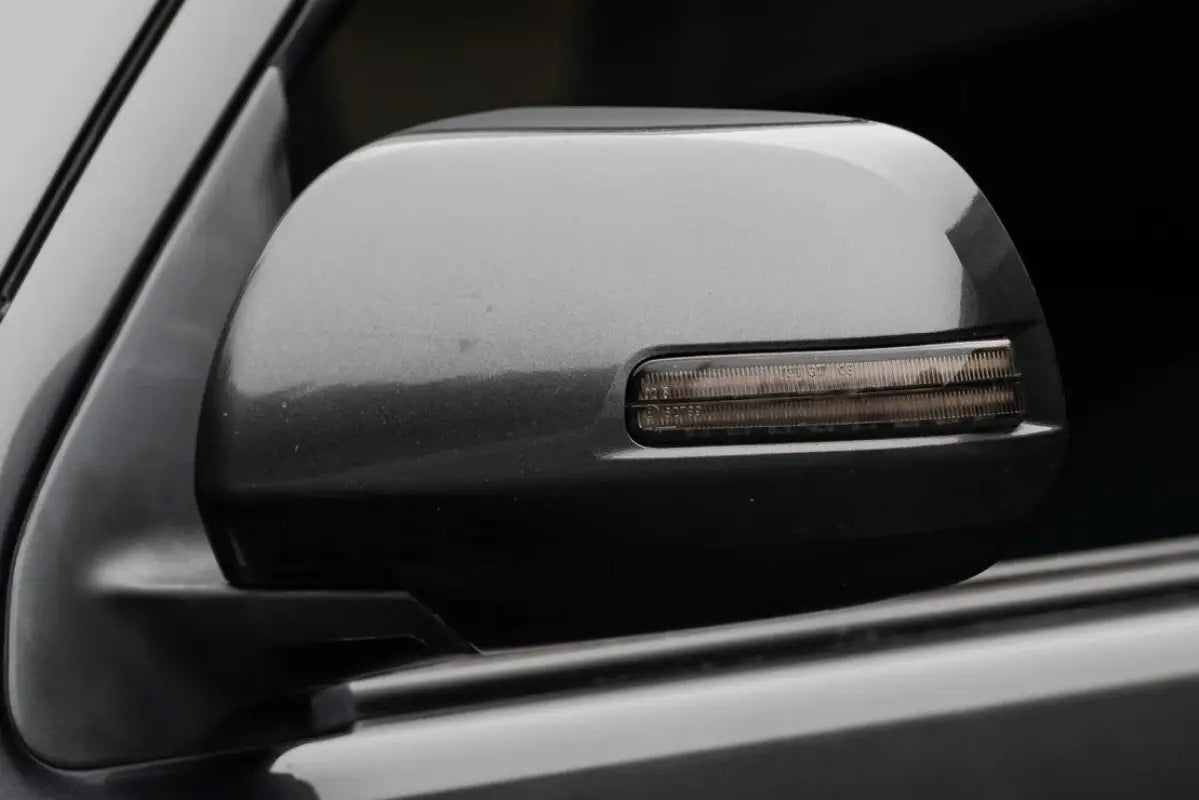 Morimoto XB turn signal installed on a side mirror of a Tacoma or 4Runner, showcasing the smoked lens design.