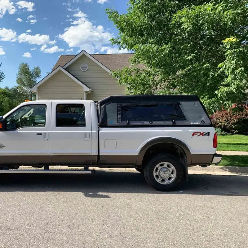 White truck with MR Full-Size Truck Topper parked in a suburban neighborhood, showcasing its sleek design and compatibility with 8-foot beds.