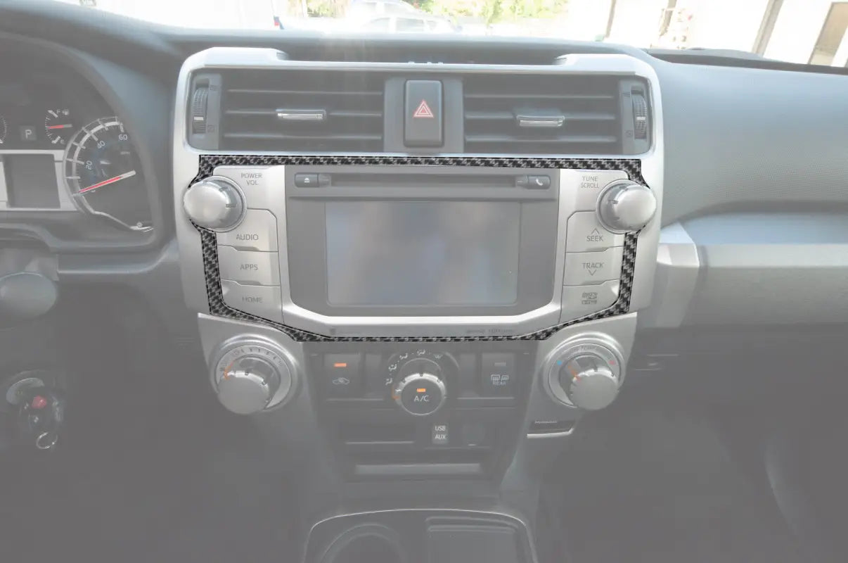 Carbon fiber-style Navigation/CD Player Outer Radio Display Accent installed on a 2014-2024 Toyota 4Runner dashboard, enhancing interior decor.