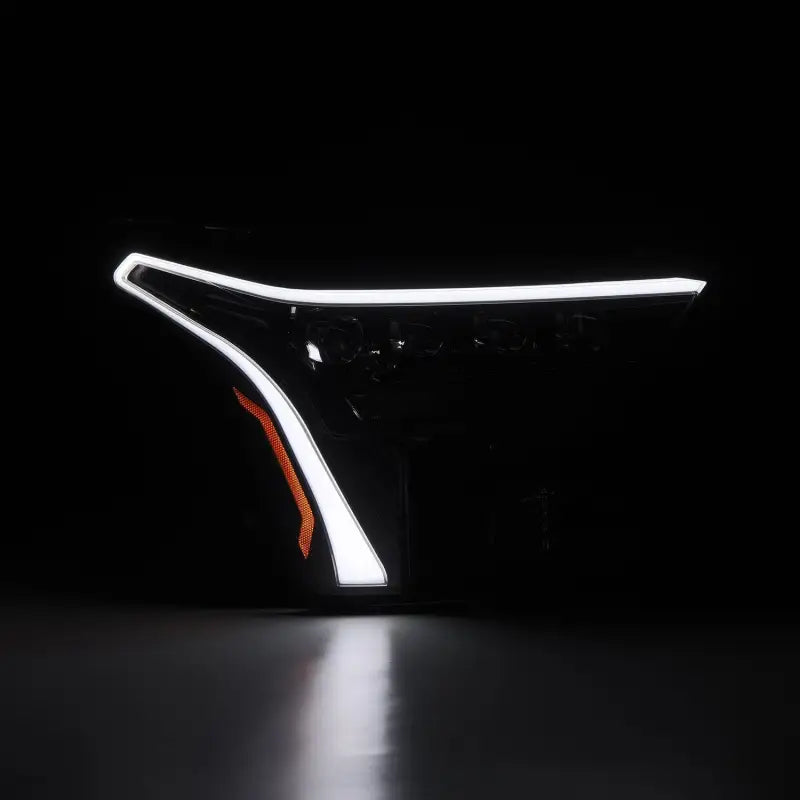 AlphaRex NOVA-Series LED projector headlight in Alpha-Black with illuminated white DRL, designed for 22-24 Toyota Tundra and Sequoia.