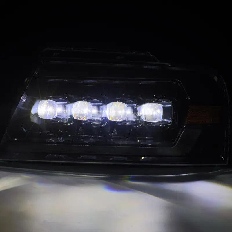 Close-up of Ford F150 04-08 LED projector headlights in black housing with bright white LED illumination.