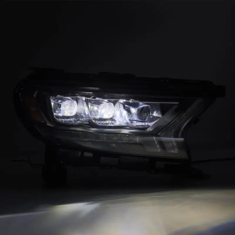 Close-up of illuminated Ford Ranger 19-22 LED projector headlights showcasing bright white light output in a dark setting.