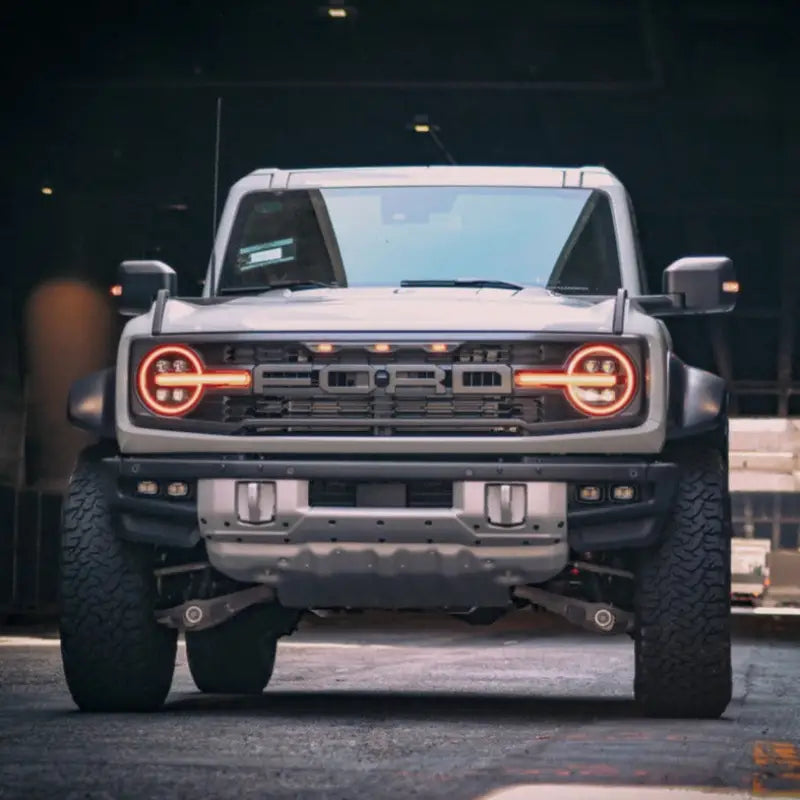 Front view of a Ford Bronco with NOVA-Series LED projector headlights, showcasing amber DRL and bold grille design.