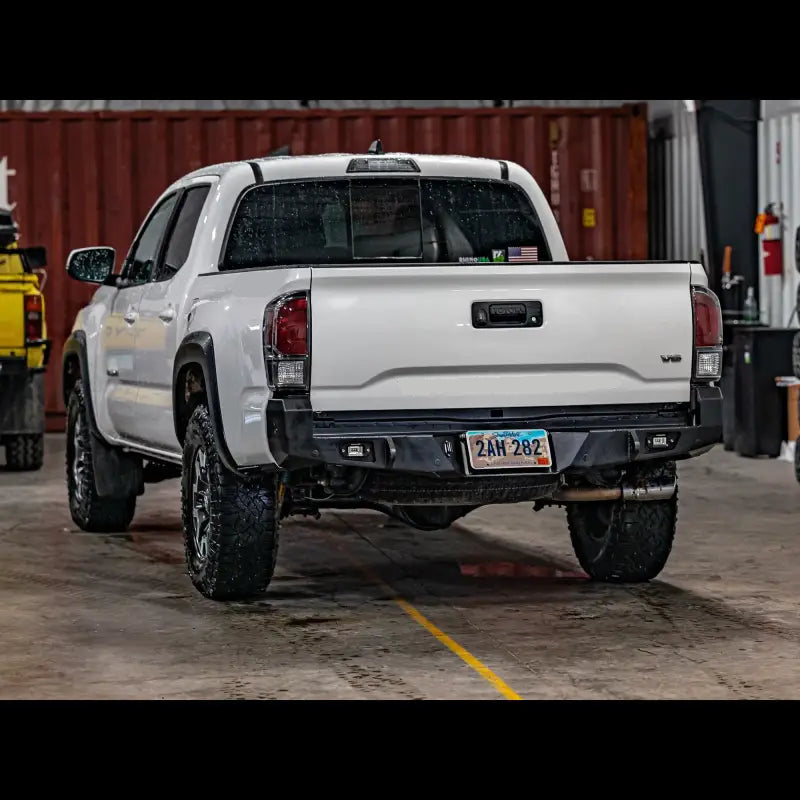 Rear view of a white 3rd Gen Tacoma with Overland Rear Bumper, showcasing high clearance design and integrated hitch for off-road use.