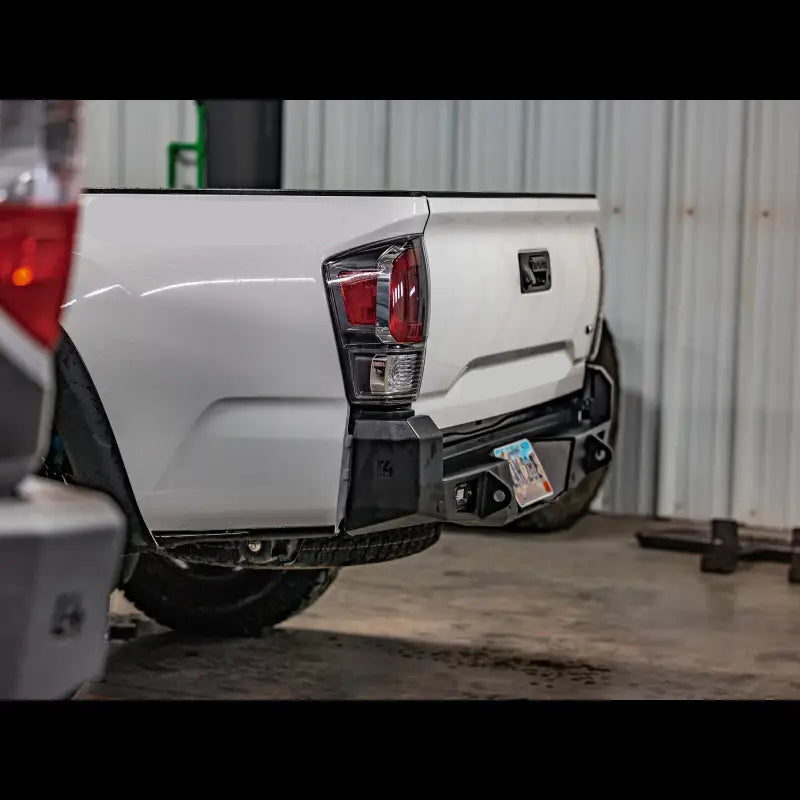 High clearance Tacoma Overland Rear Bumper for 2016+ models, featuring bolt-on installation and steel construction, mounted on a white Tacoma.
