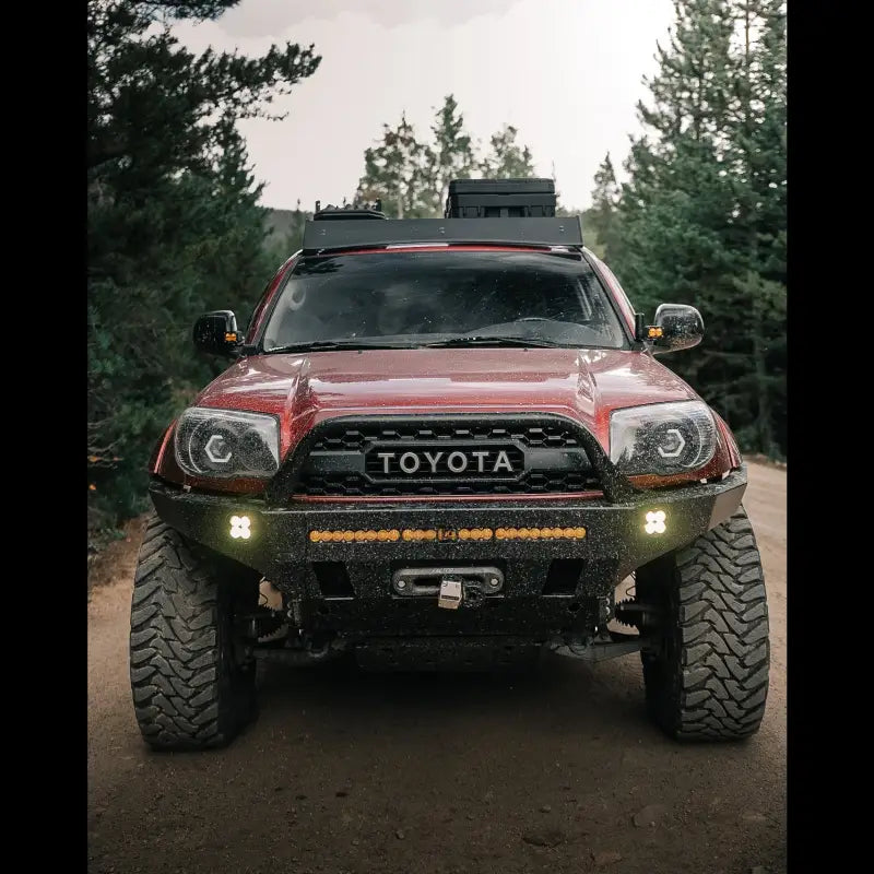Head-on view of 4Runner Overland Series Front Bumper with winch and LED lights, built for 2003-2009 models, on a dirt road.