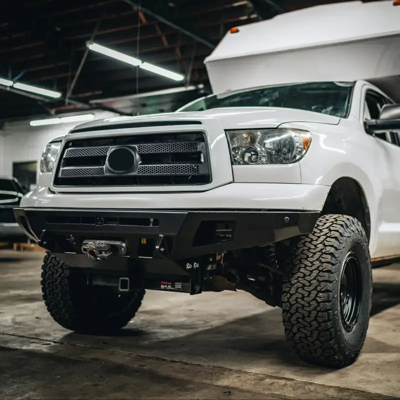 2007-2013 Tundra Overland Series front bumper installed on a white truck, featuring winch compatibility and enhanced tire clearance.