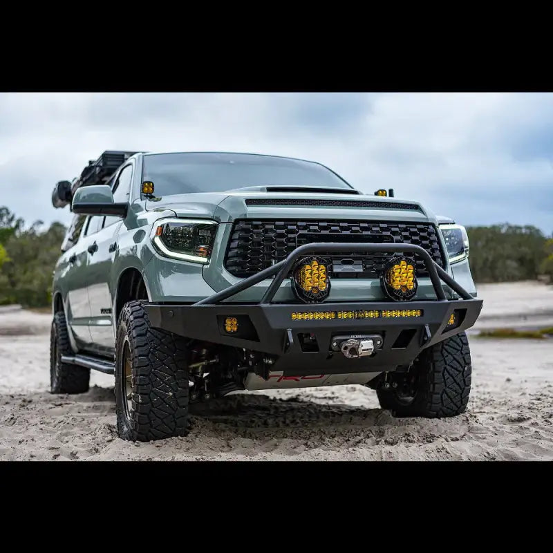 Green Toyota Tundra fitted with Overland Series front bumper, showcasing off-road lights, winch compatibility, and rugged design.